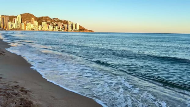 Take a moment to explore a tranquil beach scene featuring serene waves and stunning, vibrant sunset colors