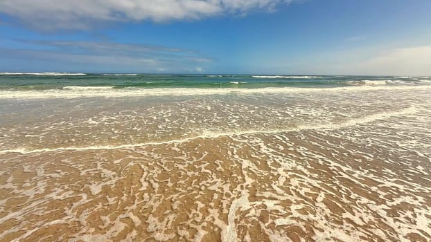 A serene and tranquil scene showcasing gentle waves slowly touching the calm shore and creating beauty