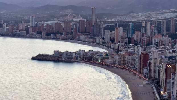 Stunning aerial shot showcases Benidorms vibrant and mesmerizing skyline beautifully lined along the coastline at dusk