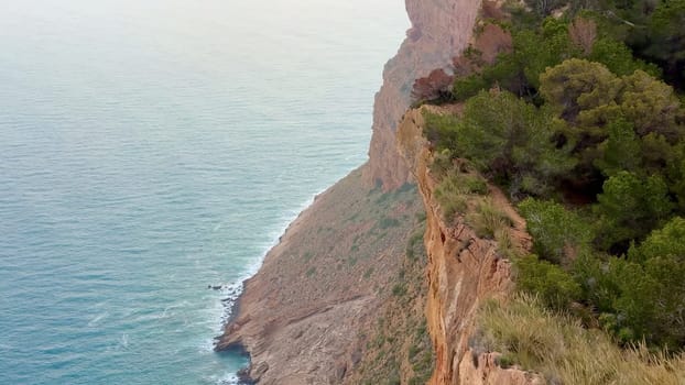 A stunning view of a rugged coastal cliff meeting the calming ocean below, perfect for nature lovers and adventurers