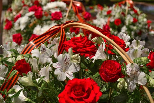 Basket with red rose and lily flowers Saint George ribbon