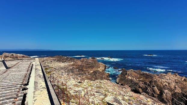 A coastal scene with rocky shores and clear blue waters under a sunny sky, creating joy and happiness