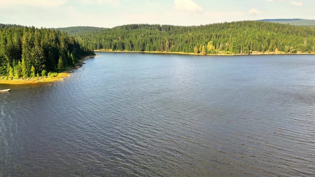 A tranquil lake reflecting the stunning scenery of lush forests, perfect for nature lovers and enthusiasts
