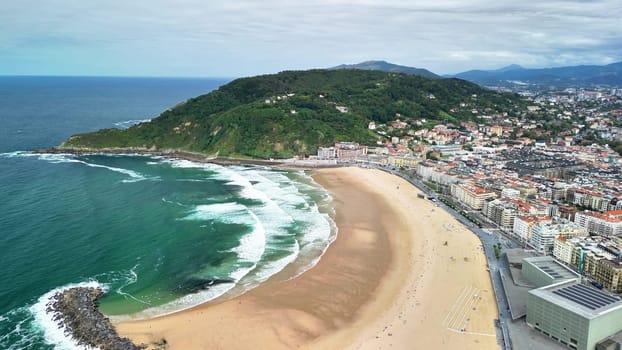 An aerial view beautifully captures the stunning sandy beach along with the vibrant urban city landscape near the coast