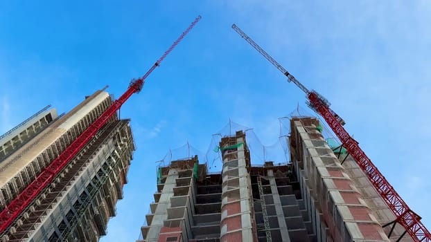 A captivating and stunning view of construction featuring cranes and skyscrapers set against a vibrant sky above