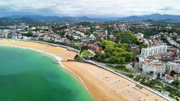 The breathtaking coastline features a beautiful sandy beach, an urban landscape, and lush vibrant greenery all around