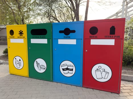 Modern waste sorting bins in an eco friendly urban environment. Yellow, green, blue, and red containers encourage proper recycling and waste management in public spaces