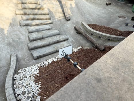 Outdoor electric fence installation with a clear high voltage warning sign. The setup highlights public safety measures in landscaped or urban play environments