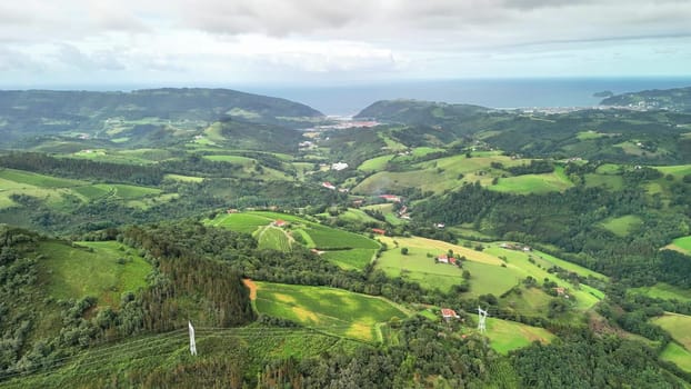 The breathtaking aerial scenery displays vibrant green hills along with the beautiful, tranquil coastline