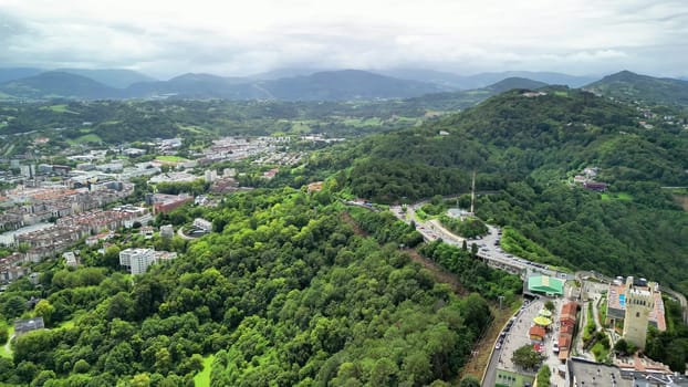 Stunning aerial shot showcasing lush greenery and urban landscapes with mountains in the background.