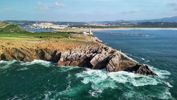 Stunning aerial views of rocky cliffs, crashing waves, and a picturesque lighthouse by the coastline.