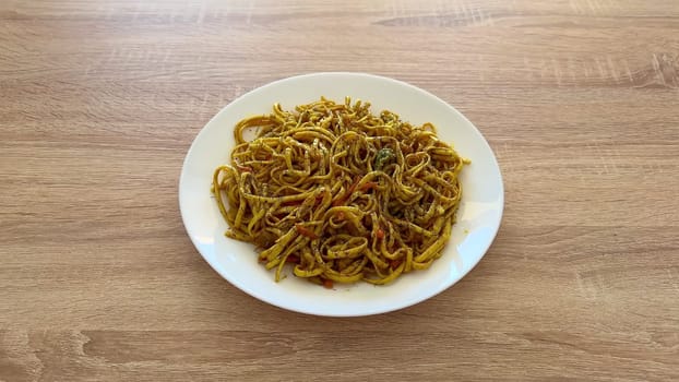 A delightful plate of wellflavored stirfried noodles, featuring a variety of vibrant spices and fresh ingredients