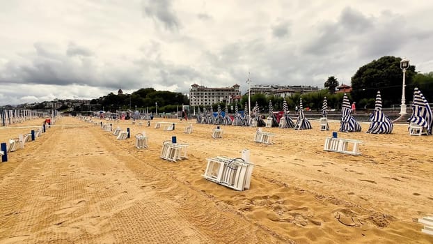 A breathtaking panoramic view of a beautiful beach showcasing colorful umbrellas and sandy shores beneath a cloudy sky