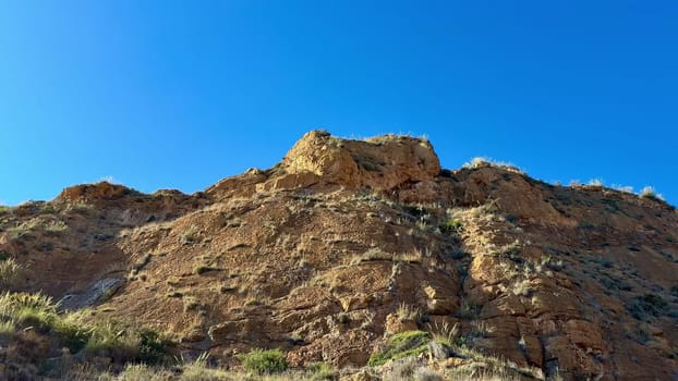 A breathtaking view showcasing impressive rocky formations alongside lush greenery beneath a clear blue sky