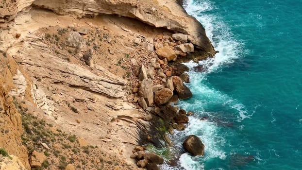 Experience the beauty of nature with this stunning coastal landscape, where waves meet rocky cliffs.