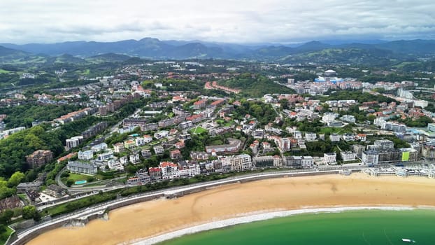 This stunning aerial shot beautifully captures a vibrant coastal town, showcasing its sandy beaches and lush greenery