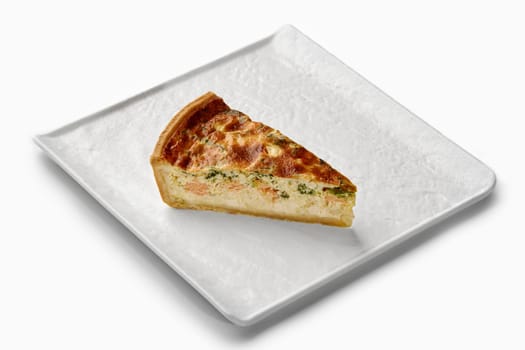 Savory quiche slice featuring salmon, broccoli, and a creamy filling, served on an elegant white plate