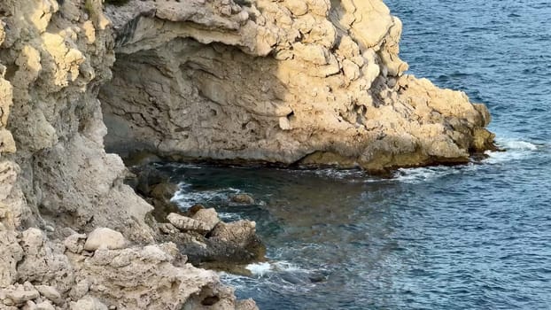 The captivating and breathtaking view showcases a rugged rocky coastline where waves gently lap against the shore