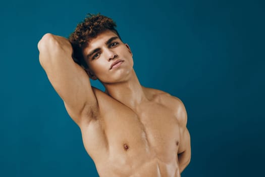Athletic male model showcasing a confident pose, emphasizing strength and style. Ideal for fitness, fashion, and lifestyle concepts. Bright blue background enhances the visual appeal.