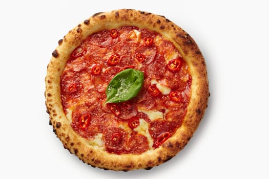Round pepperoni pizza with mozzarella cheese, chili peppers, and basil leaf on a white background