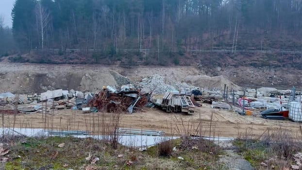 A desolate and haunting scene of wreckage, with abandoned vehicles littered throughout a construction site in nature