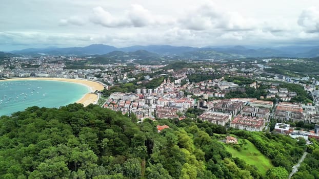 An aerial photograph shows a beautiful coastal city with stunning beaches, lush hills, and a vibrant skyline