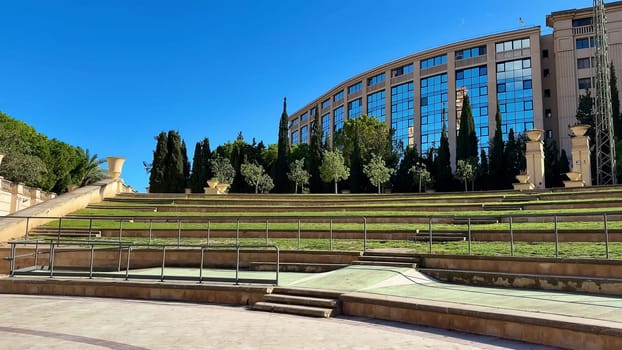 This is a beautifully picturesque view of a modern green space, which is surrounded by elegant architecture