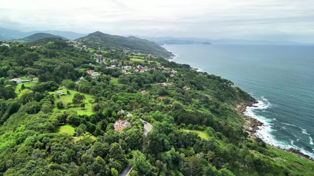 Experience a breathtaking and stunning aerial view that showcases lush green hills alongside a tranquil coastline