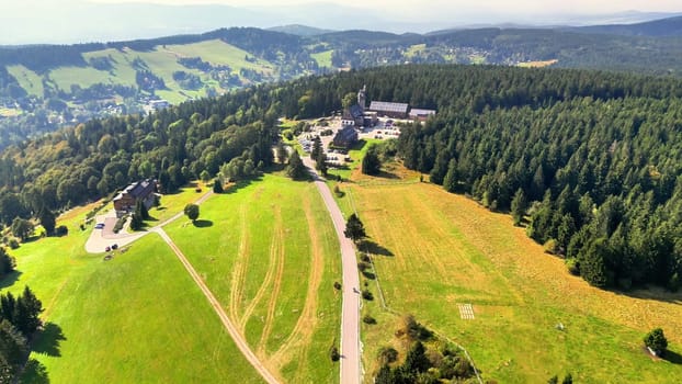 A breathtaking aerial perspective showcasing lush greenery and vast open fields surrounded by forests.
