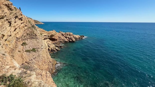 A breathtaking view reveals turquoise waters crashing against rugged cliffs within this truly serene coastal landscape