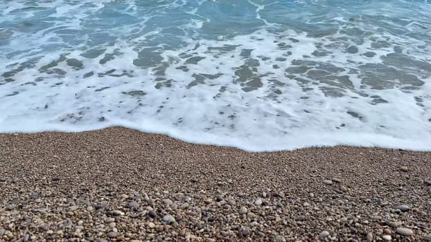 Gentle waves softly lapping against a lovely pebbly beach, creating a beautiful and serene coastal atmosphere