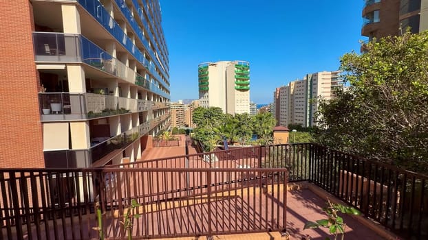 A beautiful scenic view that showcases contemporary buildings adorned with spacious balconies and vibrant greenery