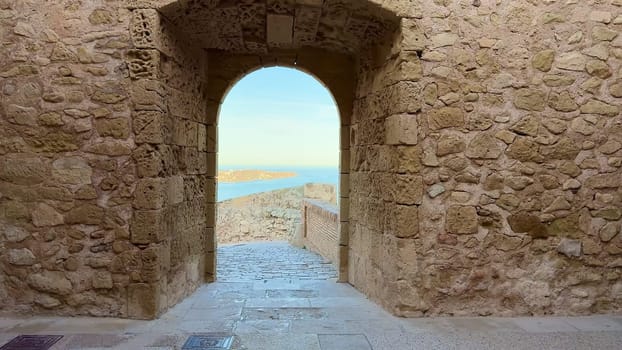 A captivating view through a magnificent stone archway revealing a truly tranquil coastal landscape ahead