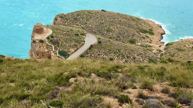 Enjoy stunning coastal views while walking a winding path along the rocky terrain by the vibrant blue sea
