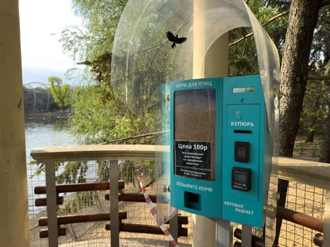 Moscow, Russia, April 23, 2025: Bird food vending machine in city park. Buy animal food and feed the bird yourself. Vending machine for buying bait in zoo. Help animal care by purchasing bird food