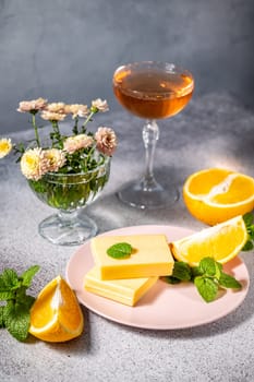 Gourmet orange flavored cheese dessert served with orange slices, mint, and a glass of wine, creating a sophisticated culinary scene