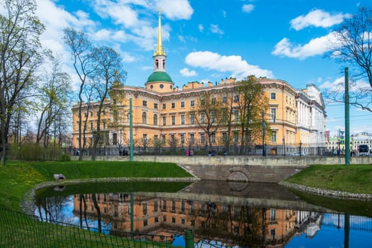 Saint Petersburg, Russia - 02.05.25. The historic Mikhailovsky Castle reflected in a canal surrounded by parkland