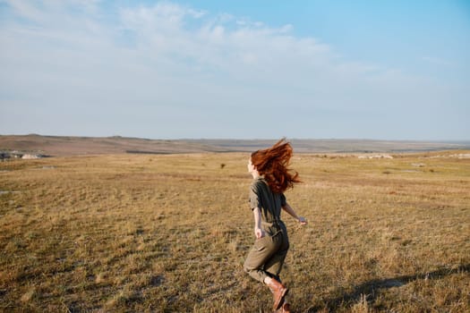 Woman running through open field in middle of day on travel adventure beauty in nature landscape concept