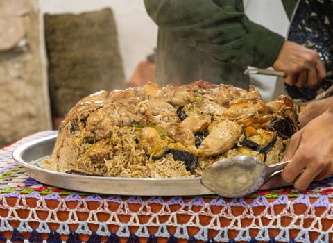 Maqluba features tender chicken, rice, and vegetables layered in a pot and flipped dramatically onto a serving platter
