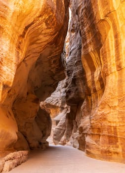 Water carved canyon walls of the narrow gorge of the Siq entering Petra in Jordan