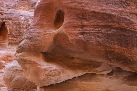Water carved the rock in the shape of the head of a fish in narrow gorge of the Siq entering Petra in Jordan