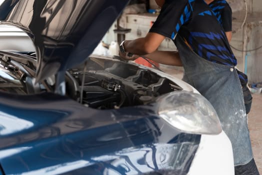 Denter or car mechanic serviceman check and fix body work and fiber bumper body part for fix and repair problem at car garage or repair shop