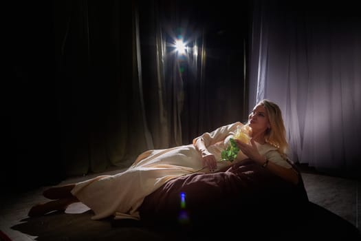 A mature blogger relaxes on a cozy surface while capturing a lifestyle moment during an indoor photo shoot.