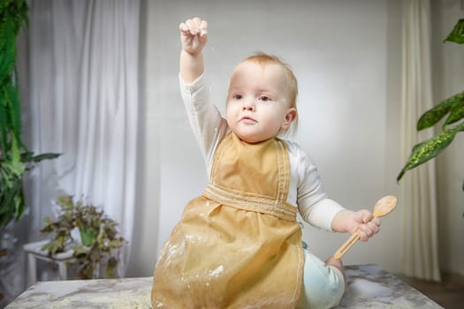 A girl explores the texture of flour while playing in a studio, showcasing a fun and creative cooking activity.