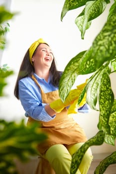 The gardener smiles while tending to the flowers in a sunny greenhouse.