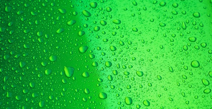 abstract green background with the texture of rain drops on a metal surface close-up