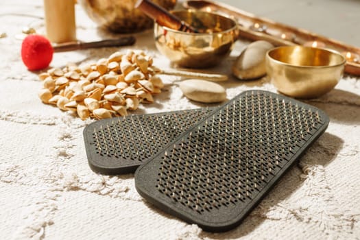 Close up of Sadhu meditation nail board with spiritual objects, singing bowls and healing tools in warm light.