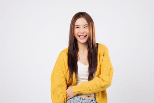 Laugh from the heart laugh with peace as a confident Asian woman smiles enjoying a lighthearted and fun lifestyle moment with natural expression isolated white background. World Laughter Day