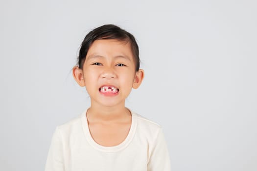 Happy child with a tooth gap. The dentist explains tooth loss and how kids experience dental changes when baby teeth fall out, revealing a cute smile.