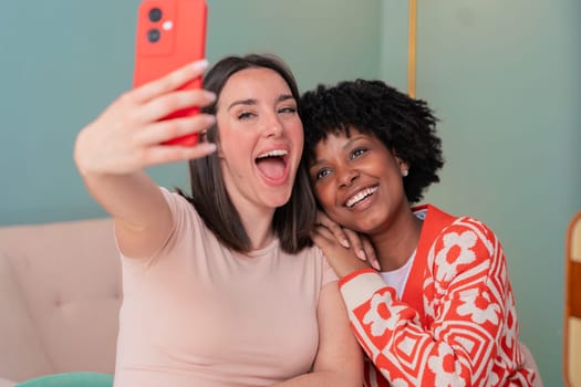 African American and Caucasian students take a cheerful selfie while studying together. They smile, pose, and enjoy a fun break indoors with notebooks, showing friendship and youthful energy.